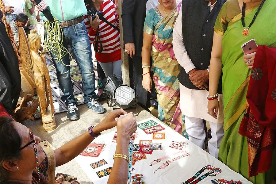 Visitors looking at block-printed textiles laid out at a handicrafts stall