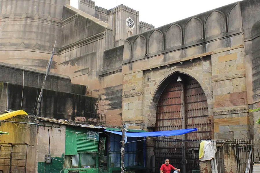 An arched gateway in the fort wall with market stalls and awnings crowded against it