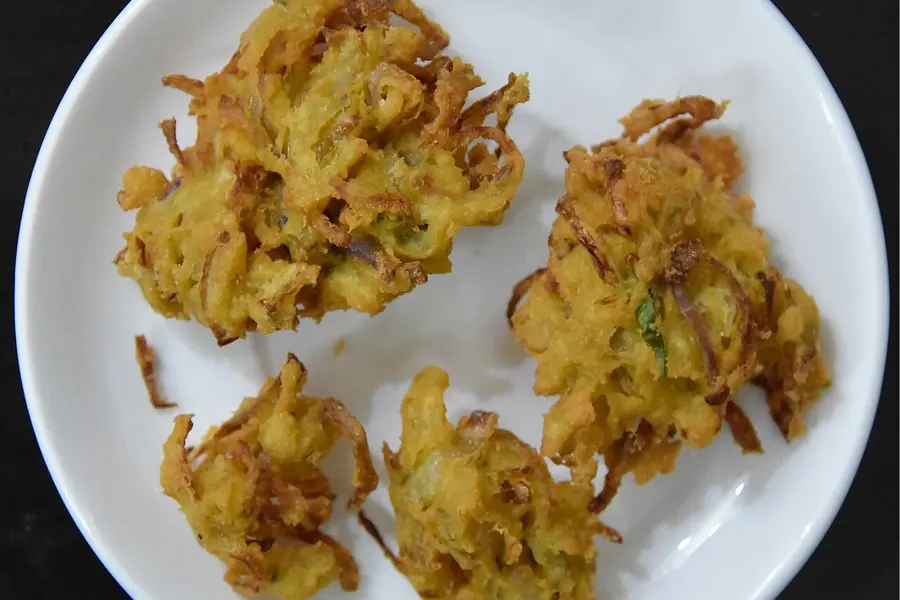 Craggy fried onion bhajiya on a white plate