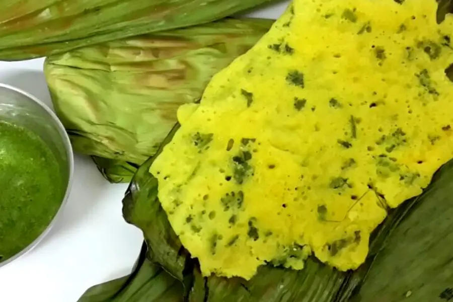 A thin yellow panki peeled back off its banana leaf