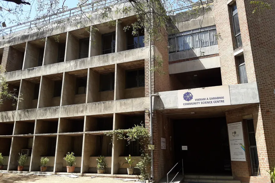 A concrete building with open balconies and the science centre's signboard by the door